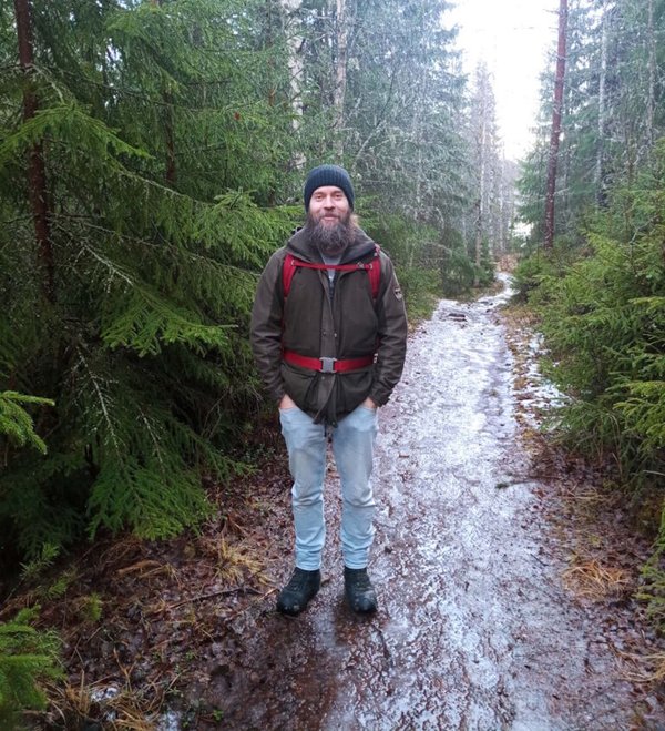 Andreas auf einem winterlichen Waldweg, mit Rucksack und Mütze